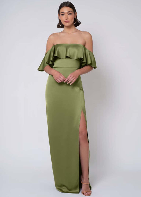 Woman wearing a green off-shoulder gown with a slit on a white background