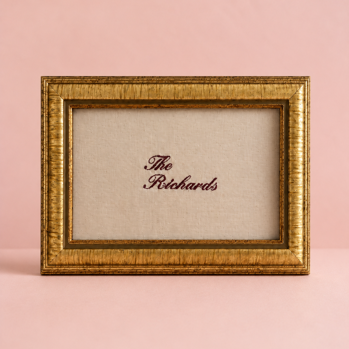 Gold-framed picture with 'The Richards' text on a pink background. A linen artwork embroidery gift