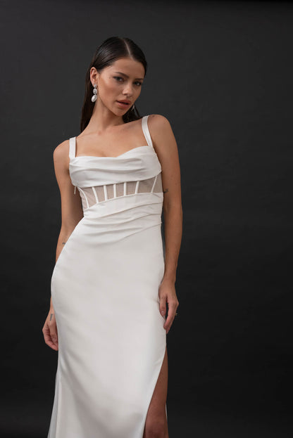 This minimalist gown is made from a stretch satin with an exposed corset lined with glitter mesh that catches the light in all the right places. Her sweetheart illusion bodice features exposed boning and asymmetrical draping from the waistline that is ruched to accentuate your curves. Her fitted slimline skirt hugs the body with a left leg hemline split for a touch of skin