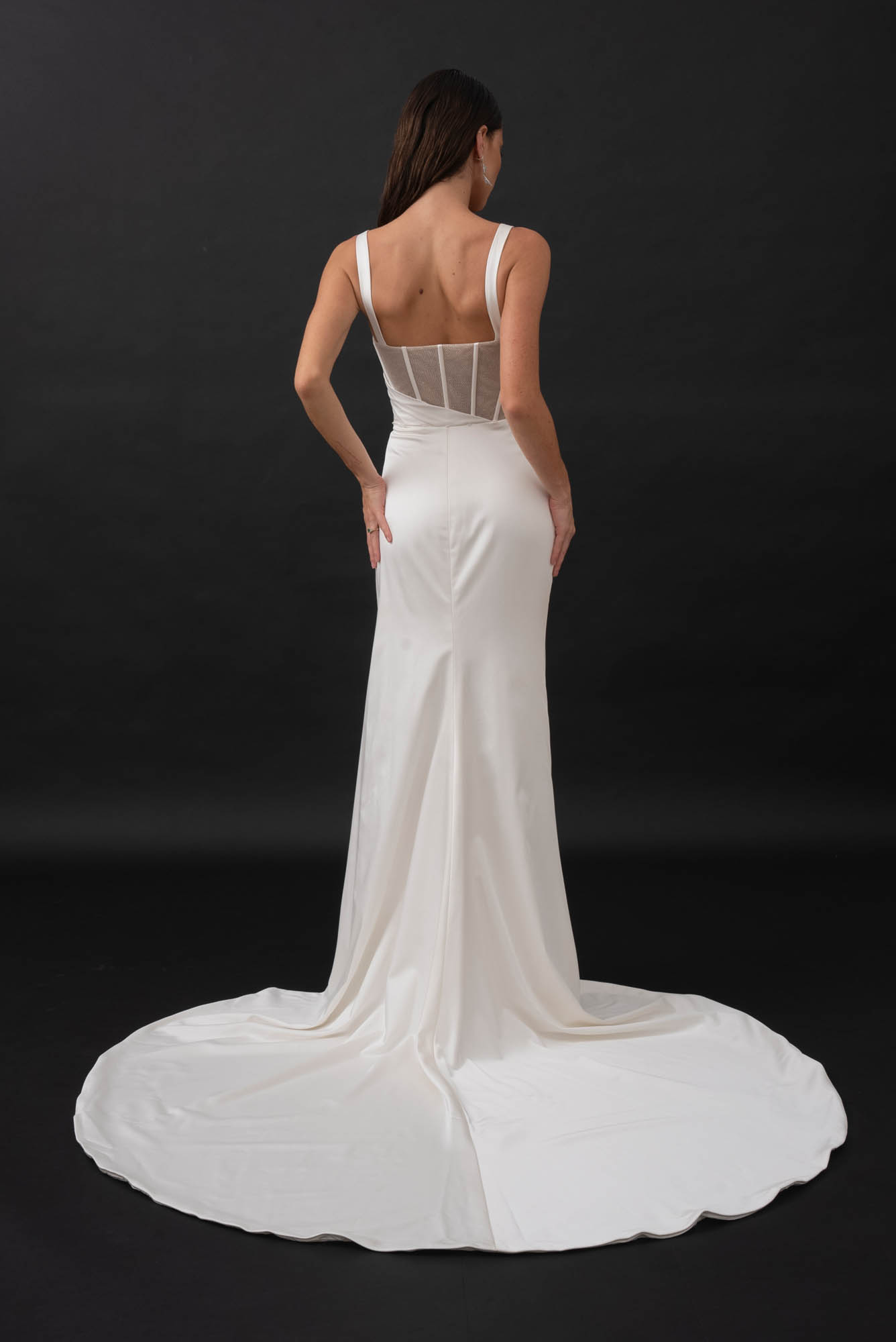 This minimalist gown is made from a stretch satin with an exposed corset lined with glitter mesh that catches the light in all the right places. Her sweetheart illusion bodice features exposed boning and asymmetrical draping from the waistline that is ruched to accentuate your curves. Her fitted slimline skirt hugs the body with a left leg hemline split for a touch of skin