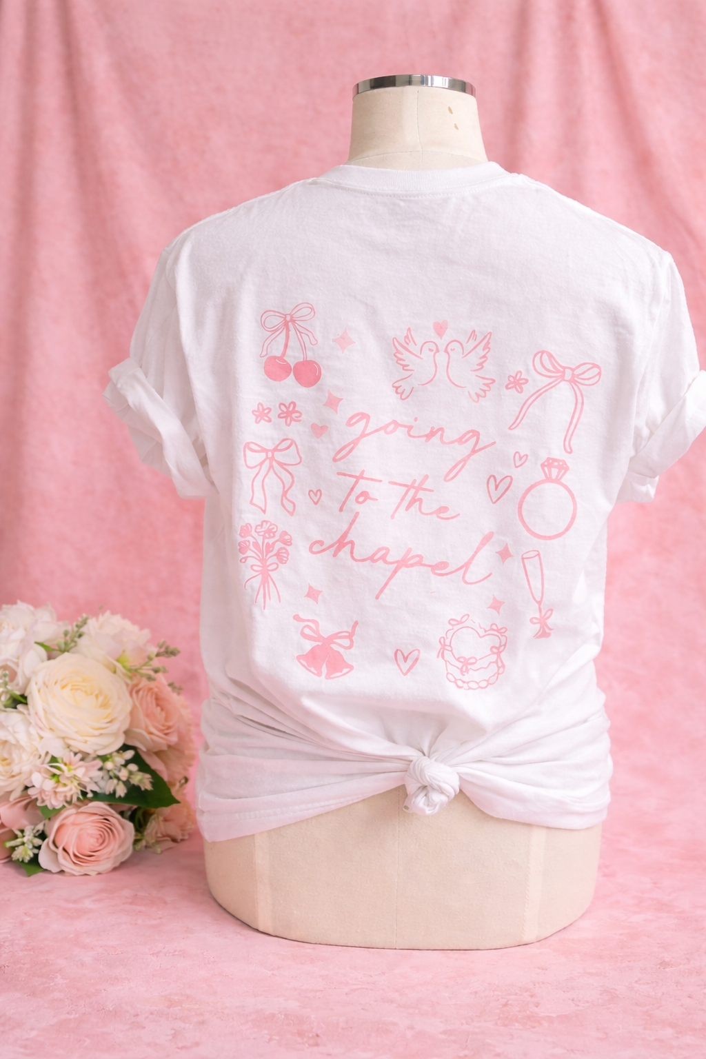 mannequin wearing a white t-shirt with pink text "going to the chapel" and wedding graphics on a pink background