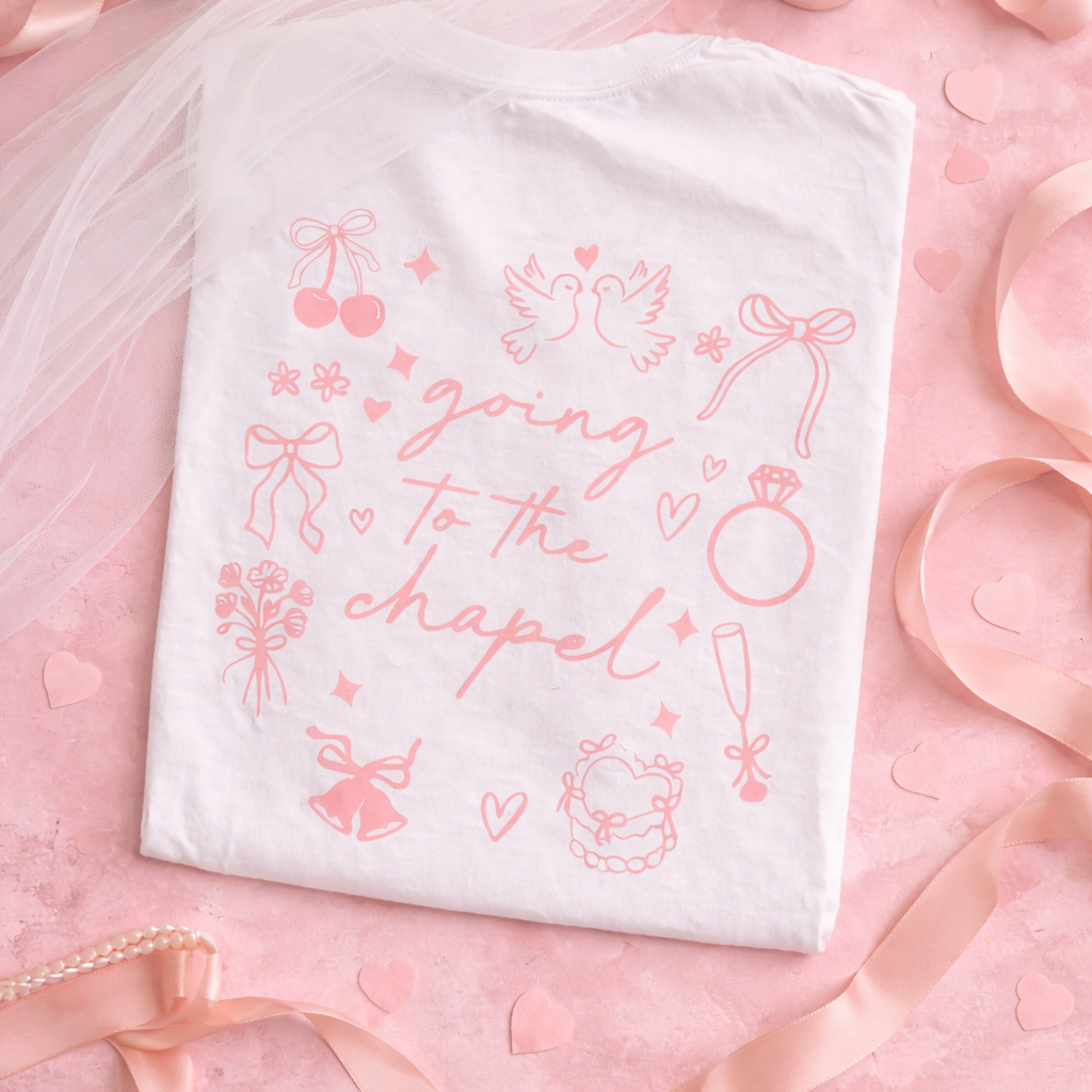 white t-shirt with pink text "going to the chapel" and wedding graphics on a pink background. wedding thenmed background