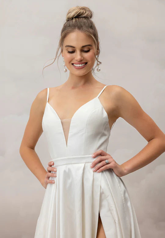 Woman wearing a white dress with a plain background