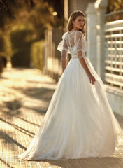 Young woman wearing a wedding dress with a full skirt, outlined bust and puffy sleeves - back view
