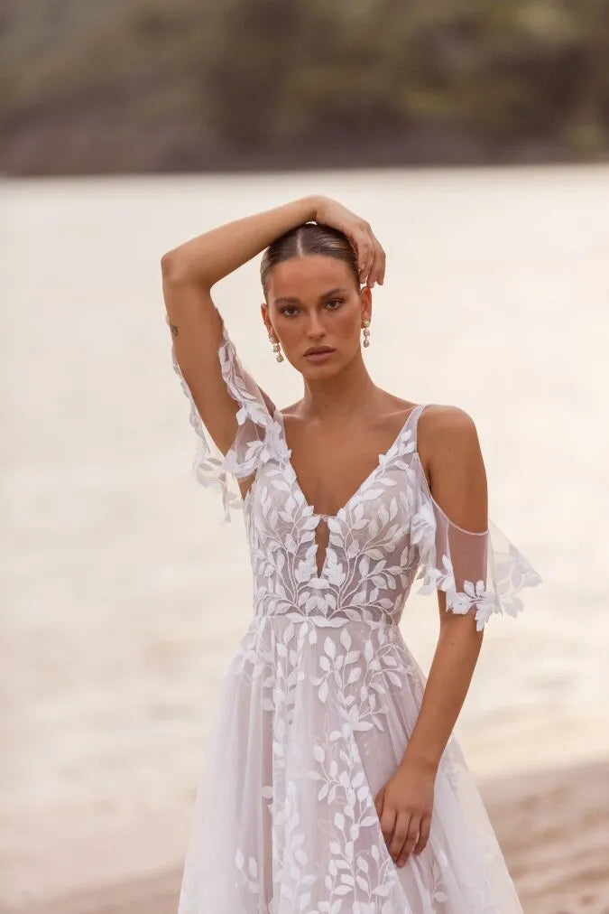 Woman wearing a white lace dress on a beach