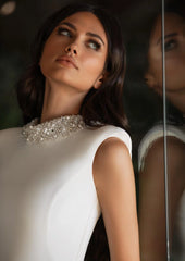 Model wearing Kerr by Pronovias - a high neck fitted wedding dress with a beaded neckline - close up front view