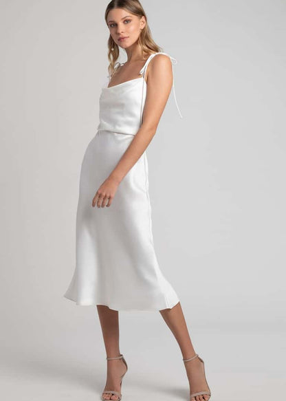 Woman wearing a white satin dress on a plain background