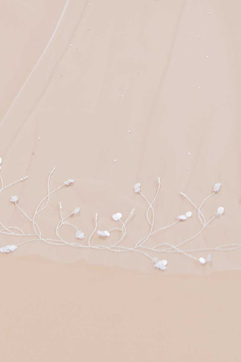 Delicate white floral veil on a beige background