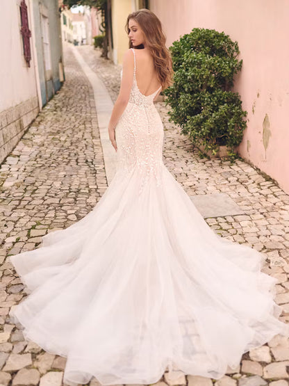 Model wearing Ernestine by Maggie Sottero. Discontinued fit and flare lace loral mermaid wedding dress. Showing off the low scoop back