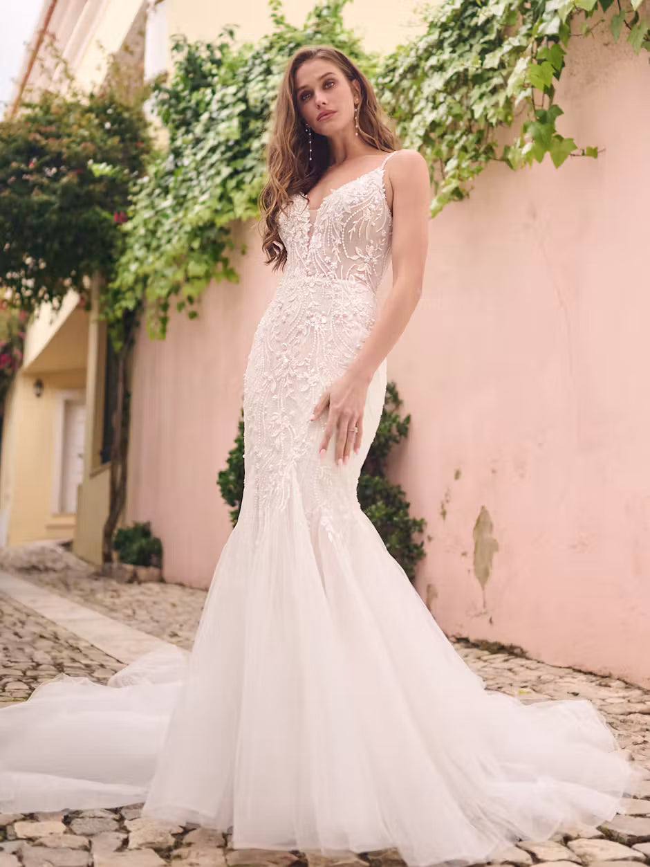 Model wearing Ernestine by Maggie Sottero. Discontinued fit and flare lace loral mermaid wedding dress