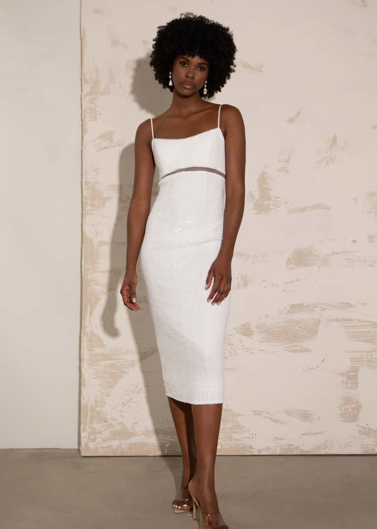 Woman wearing a white dress against a neutral background