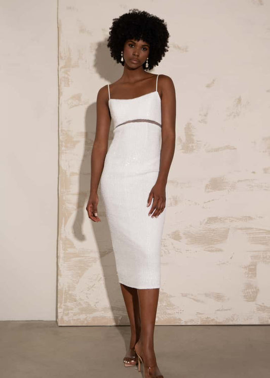 Woman wearing a white dress against a neutral background