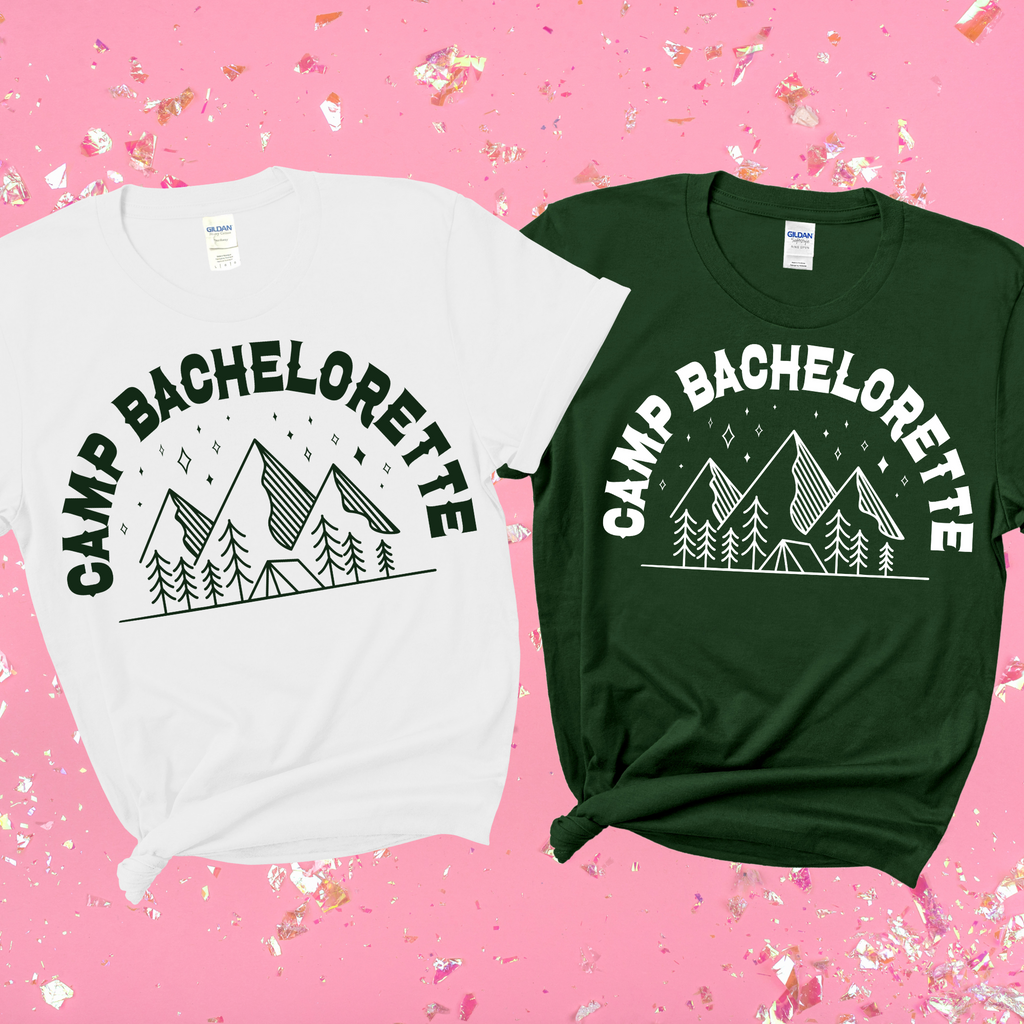A white and green shirt both with "camp bachelorette" on a pink background