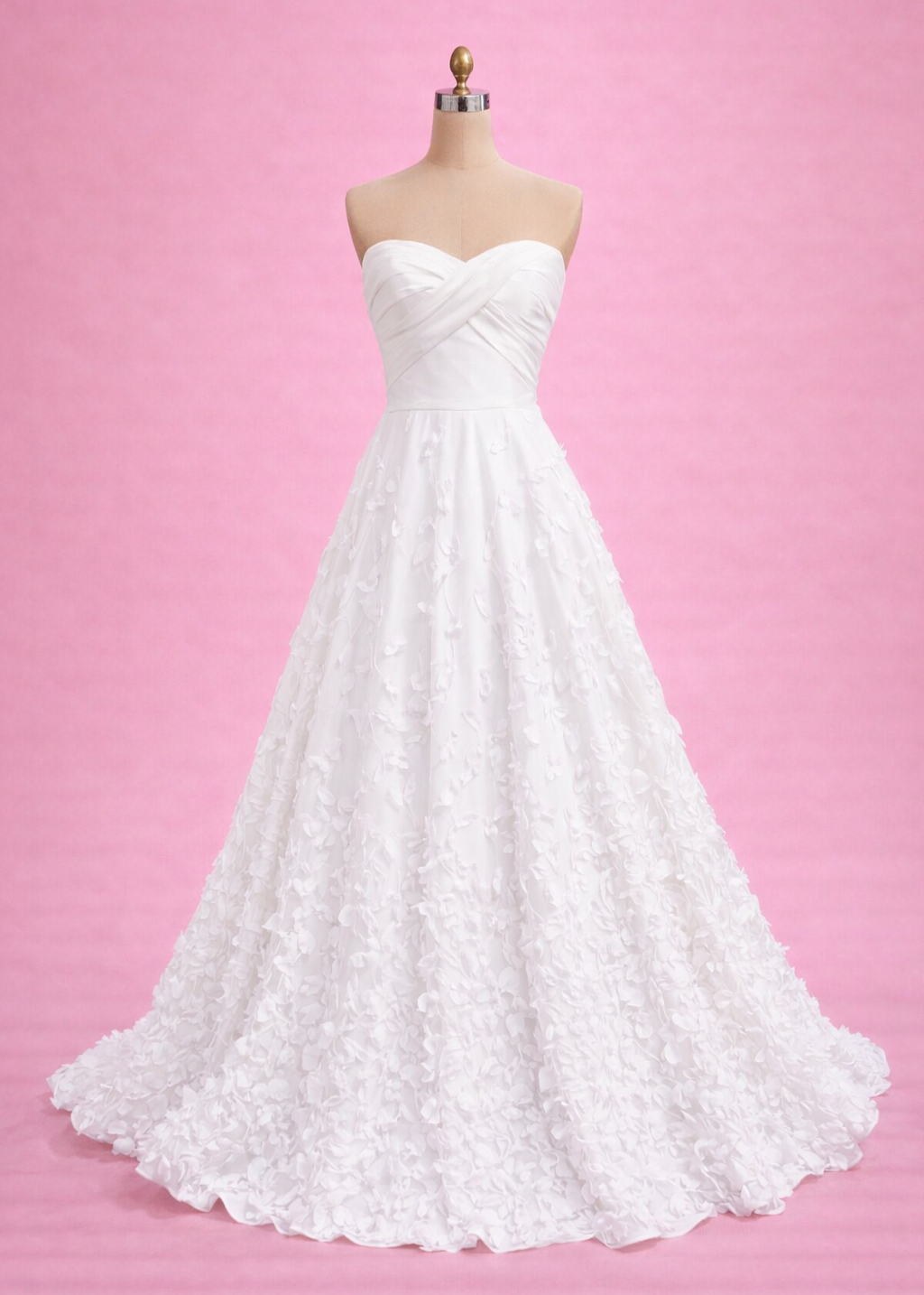 White wedding dress on a mannequin against a pink background