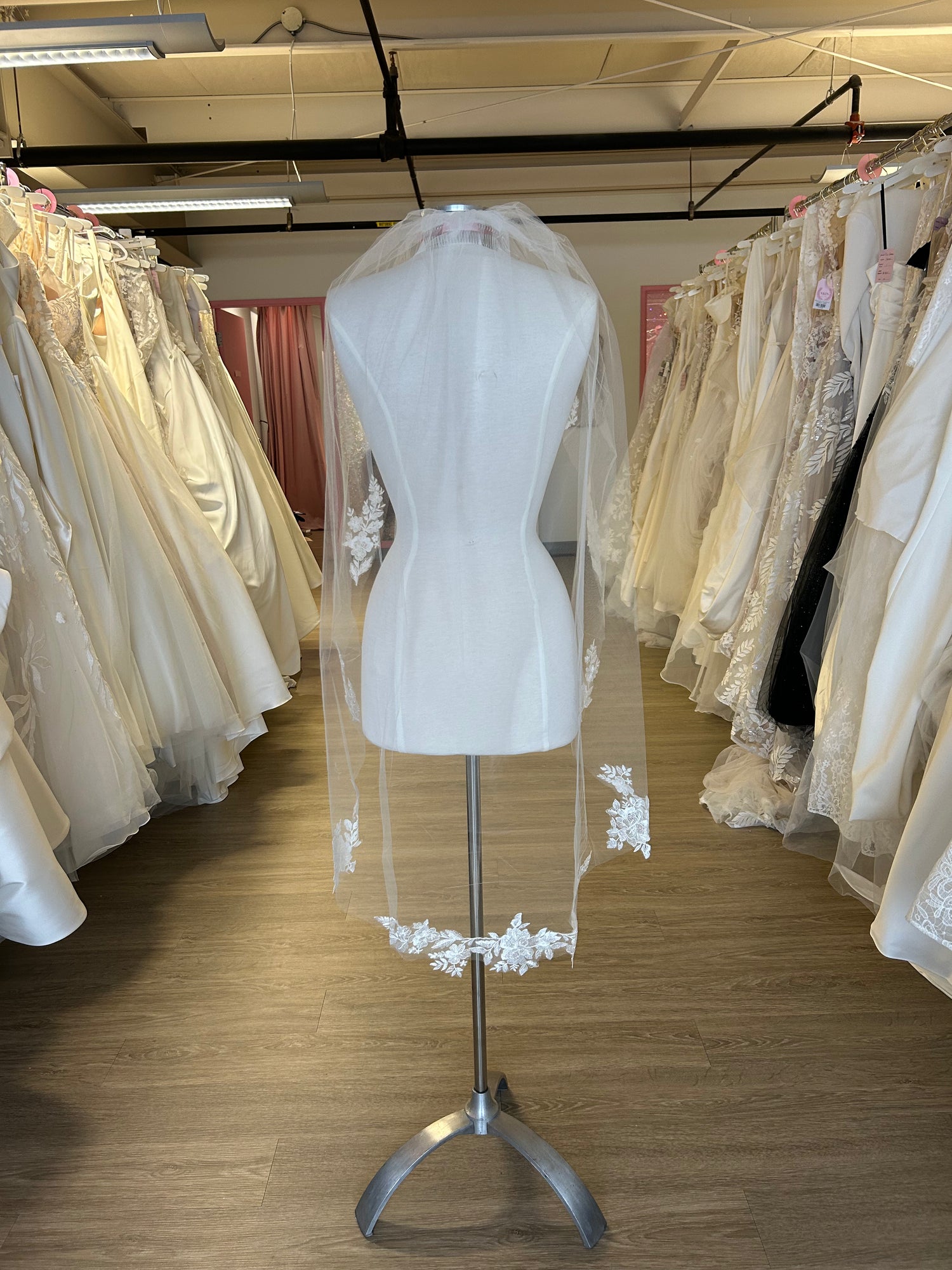 Mannequin wearing a white wedding dress with a veil in a store setting