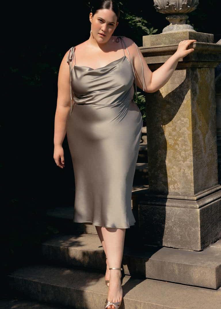 Woman in a moss dress standing on stone steps outdoors