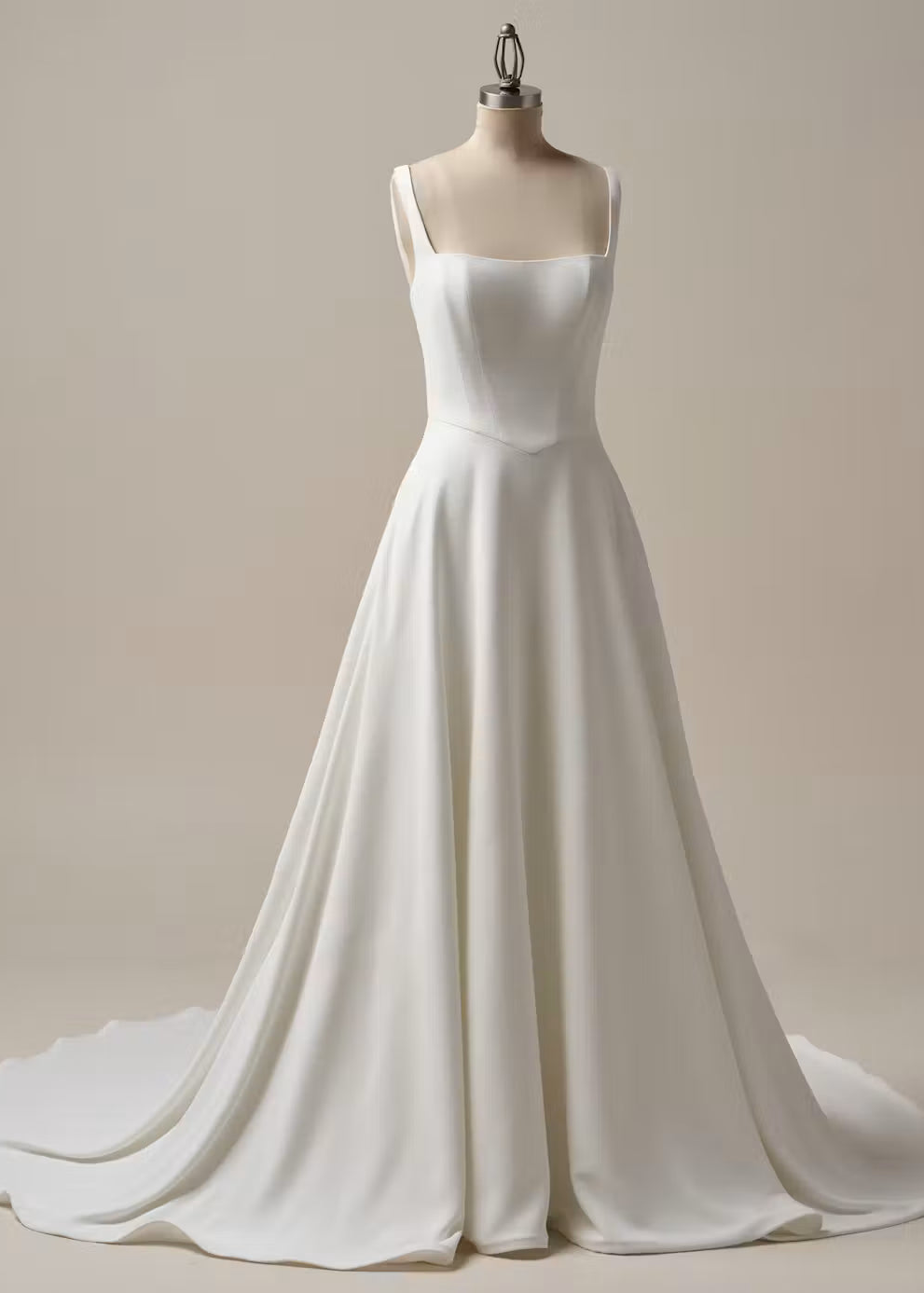 An ivory A-line wedding dress with a square neckline and thin shoulder straps, displayed on a mannequin against a warm beige studio background.