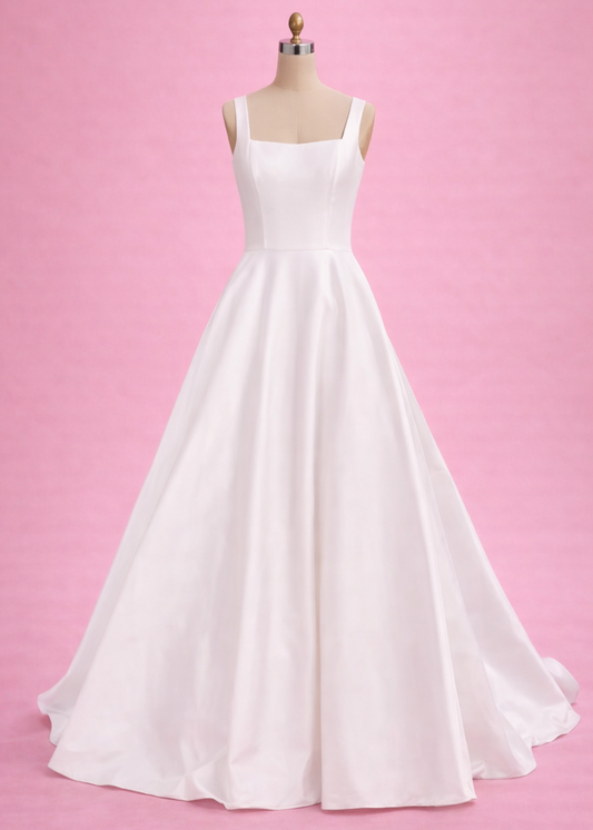 White wedding dress on a mannequin against a pink background