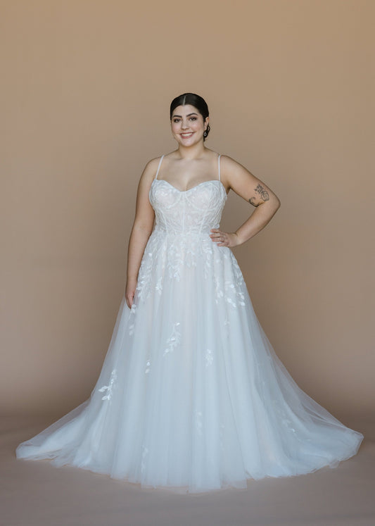 Woman wearing a white wedding dress against a beige background