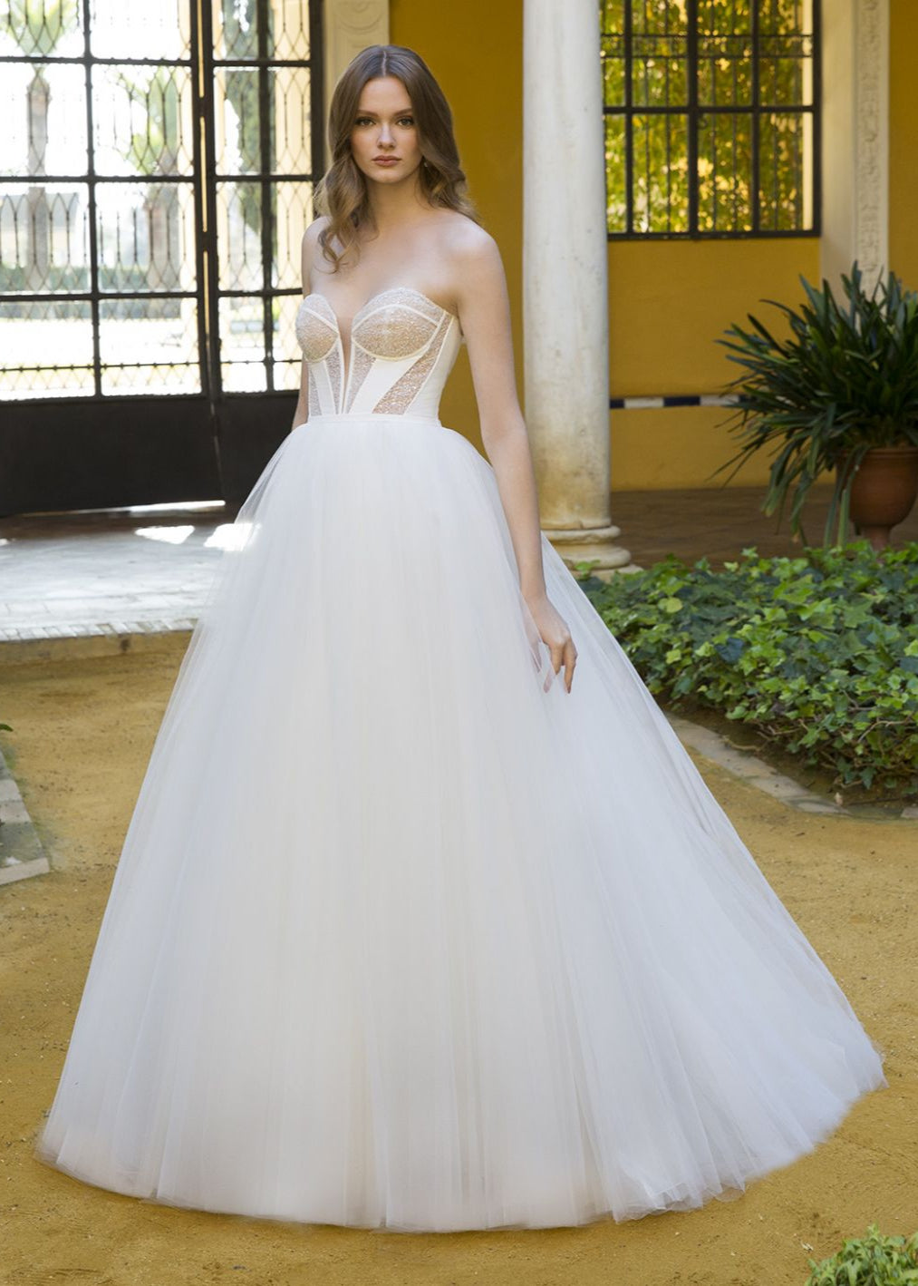 Woman wearing a white wedding dress with a yellow interior background