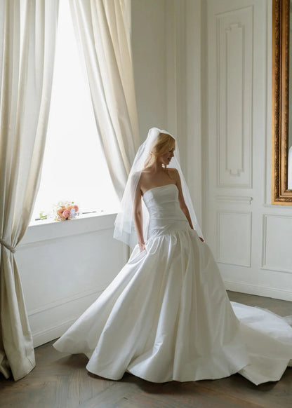 The show stopping Parvati gown with a dropped waist ballgown is what bridal dreams are made of. Corset construction for security and a flattering bodice. With a straight neckline, and oh did we mention, she has pockets!