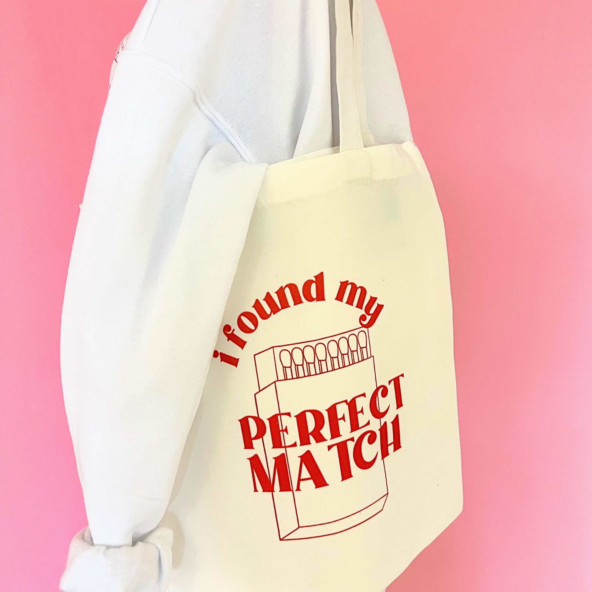 Beige tote bag with red text 'I found my perfect match' on a pink background