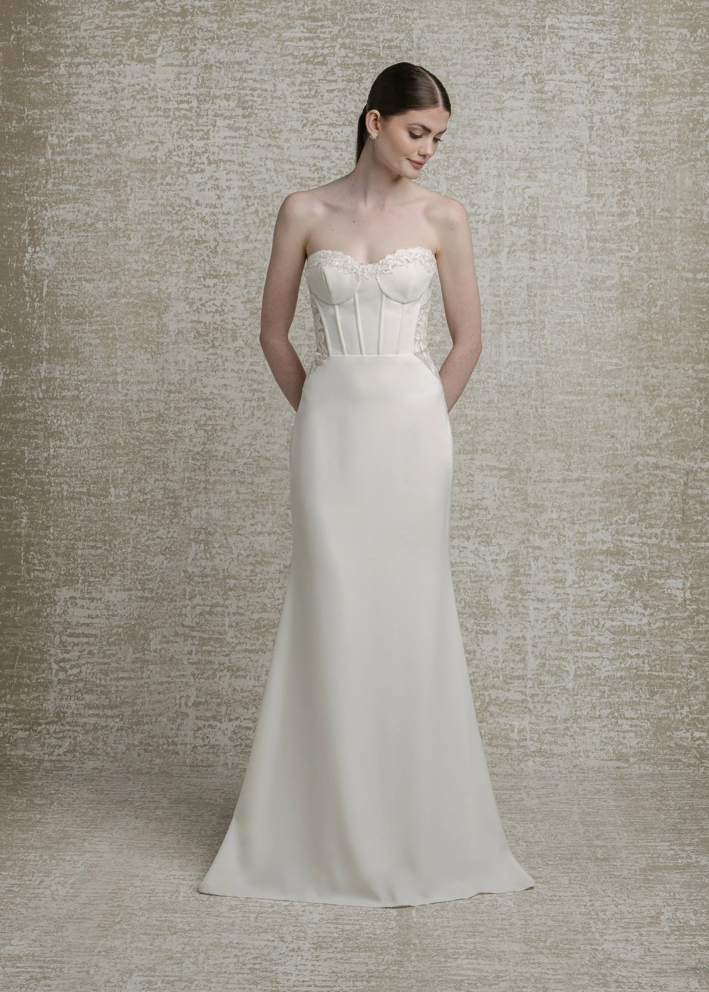 Mikado crepe, strapless sweetheart neckline with decorative boning and sequinned lace illusion cutouts, fit to flare skirt, zip closure with decorative buttons down illusion cutout chapel train. 

