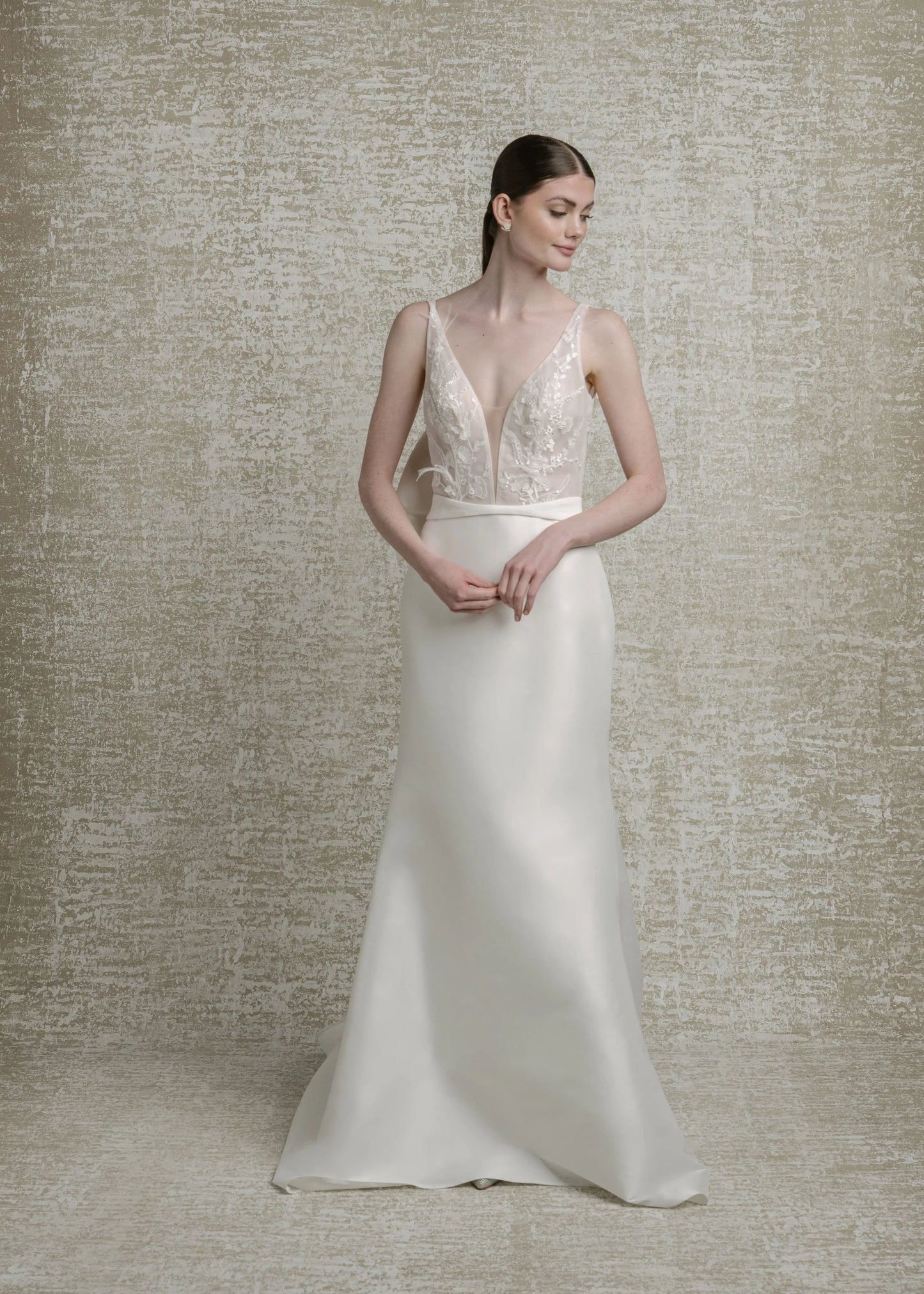 Beaded, feathered, and 3D floral lace bodice, deep V neckline, extra low V back, mikado fit to flare skirt, zip closure with decorative buttons down chapel train. Detachable contoured belt with attached structural bow. 

