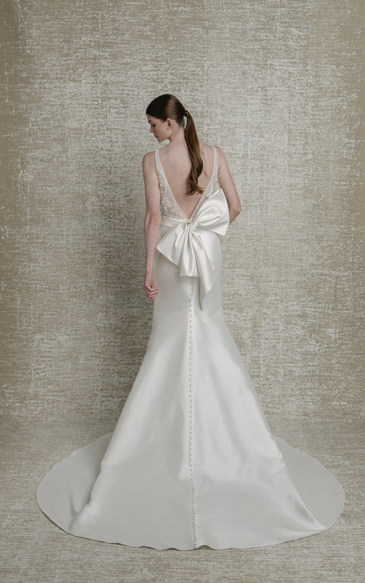 Beaded, feathered, and 3D floral lace bodice, deep V neckline, extra low V back, mikado fit to flare skirt, zip closure with decorative buttons down chapel train. Detachable contoured belt with attached structural bow. 

