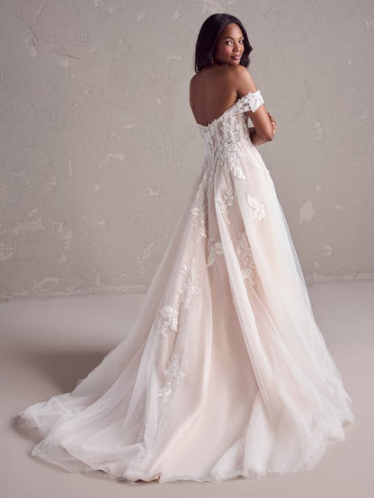 Woman wearing a white lace wedding dress against a neutral background