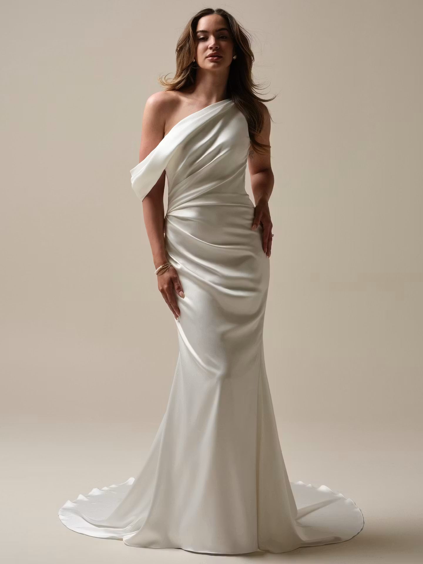 Single shoulder Ganavi stretch Satin strap with button closure and off-the-shoulder draped cap-sleeve wedding dress at NKIN in Ottawa
