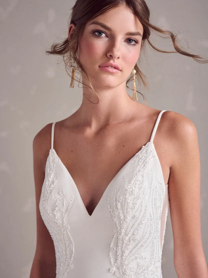 Woman wearing a white lace dress against a neutral background