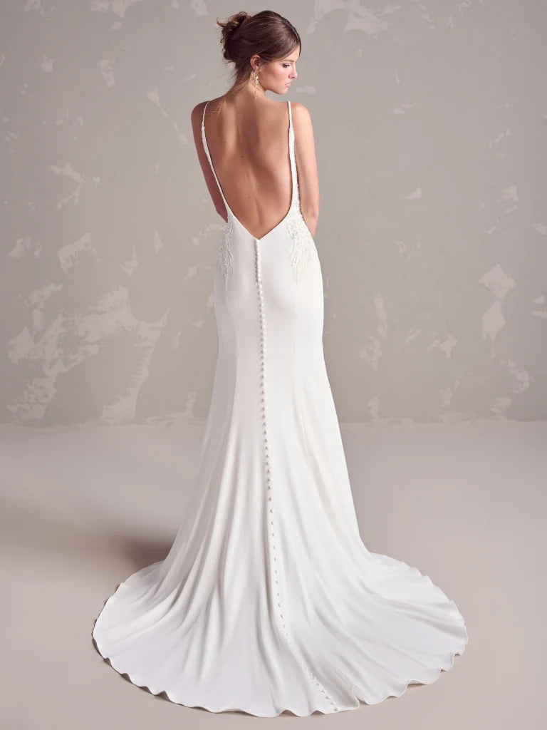 White wedding dress with open back on a neutral background