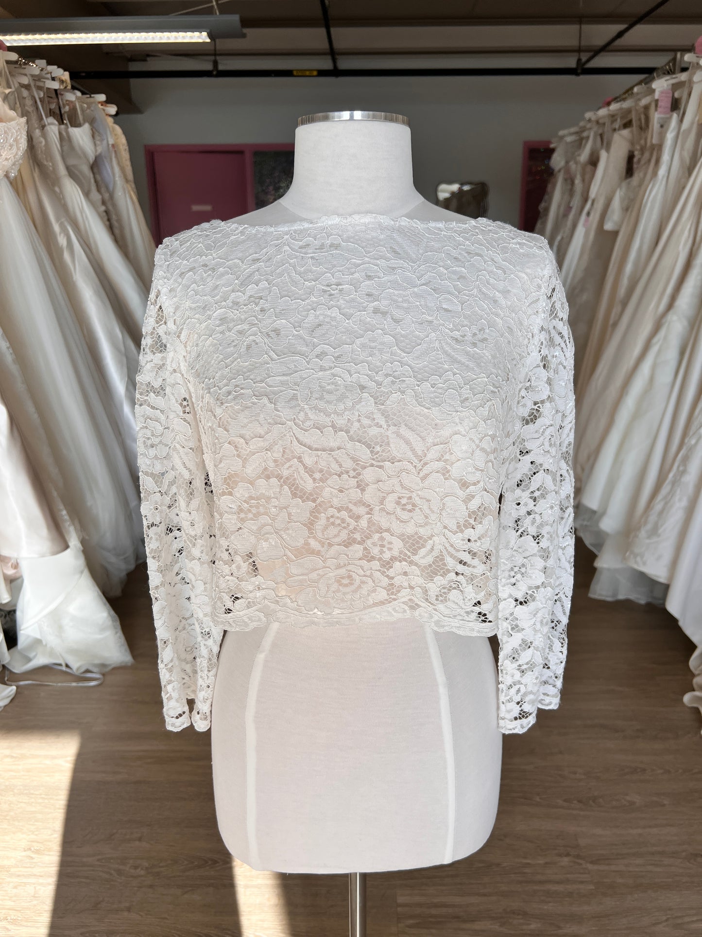 White lace garment on a mannequin against a neutral background