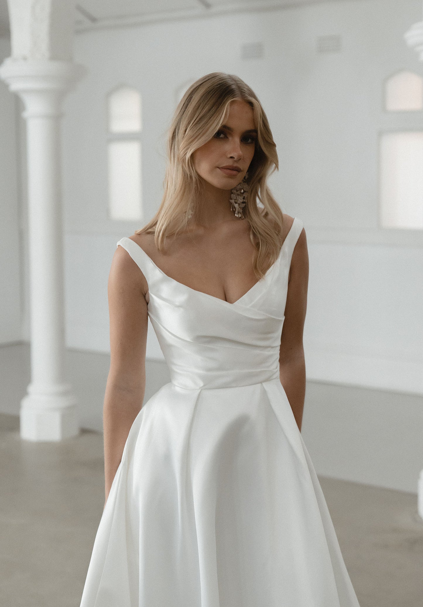 Seldon captures the essence of simple elegance, showcasing a pleated bodice that gracefully complements her shallow V neckline and signature Mikado fabric.