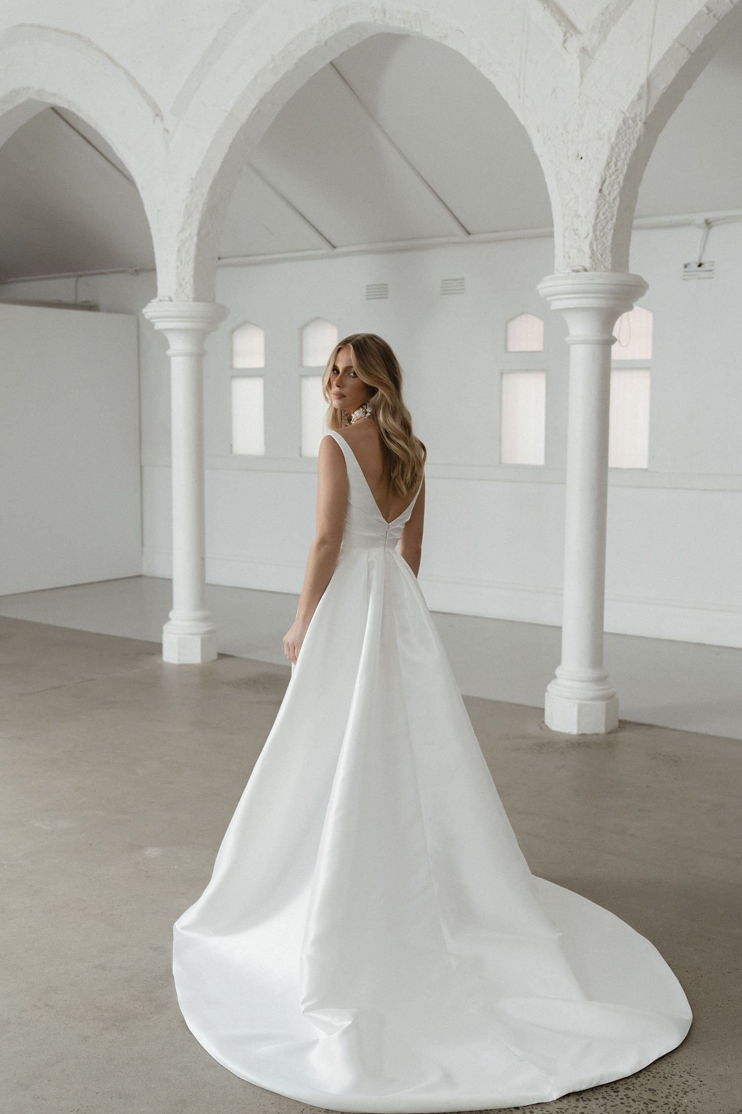 Seldon captures the essence of simple elegance, showcasing a pleated bodice that gracefully complements her shallow V neckline and signature Mikado fabric.