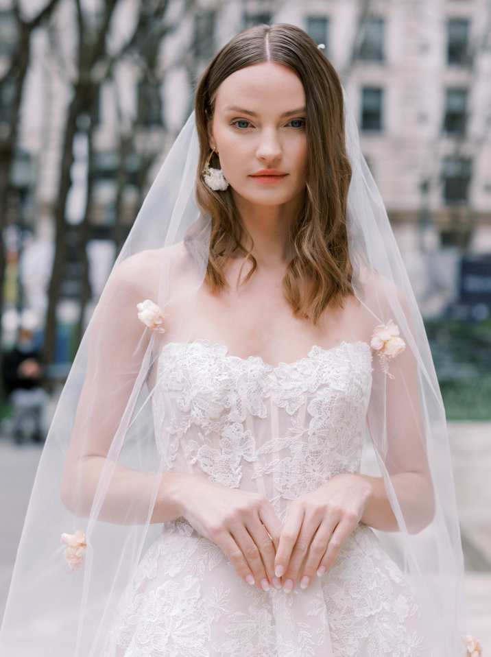 Woman wearing a veil and wedding dress - fully lace ball gow nwith a soft square neckline mclose up