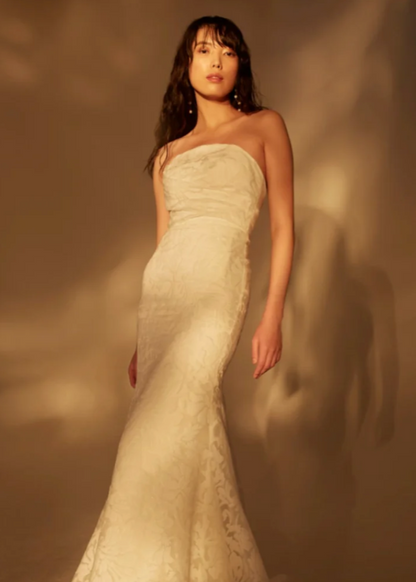 Model wearing Wave by Theia Couture - a strapless floral burnout fit and flare wedding dress - full body front view