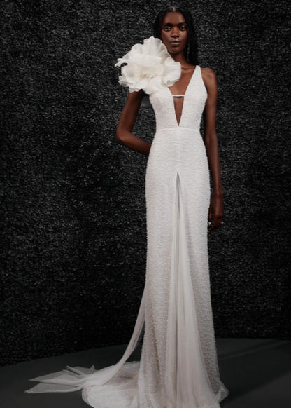 Model wearing Carole by Vera Wang - a fitted beaded wedding dress with a deep V neck and floral shoulder attachment,  full body front view