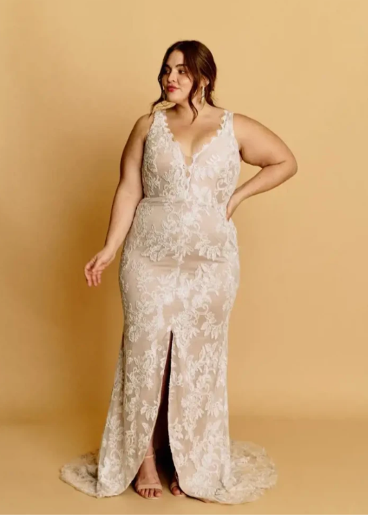 Woman wearing a nude wedding dress, a front slit with a v necklline and full lace