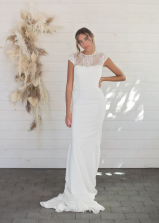  A sheath crepe gown with a modified scoop neckline topped with a delicate and soft chantilly lace that softly covers the neck and back, allowing the skin to be showcased under the stunning lace - full body front view