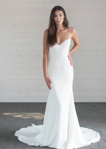 a captivating plunging v-neckline, a flattering fit and flare skirt, and delicate lace detailing throughout - full body front view