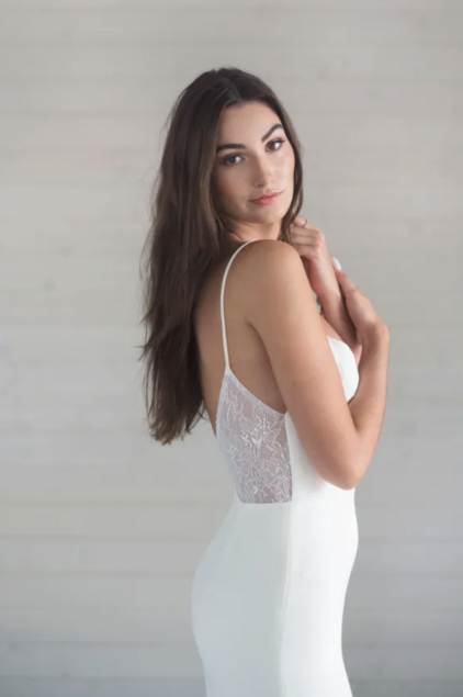a captivating plunging v-neckline, a flattering fit and flare skirt, and delicate lace detailing throughout - close up side view
