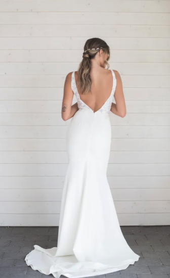 Elizabeth features a classic, deep plunging neckline and a very flattering sheath skirt. Elizabeth features hand-sewn lace in the waistband making the transition from top to bottom very smooth. The stunning and daring low v-back elongates the body and melts effortlessly into its simple, classic train - full body back view
