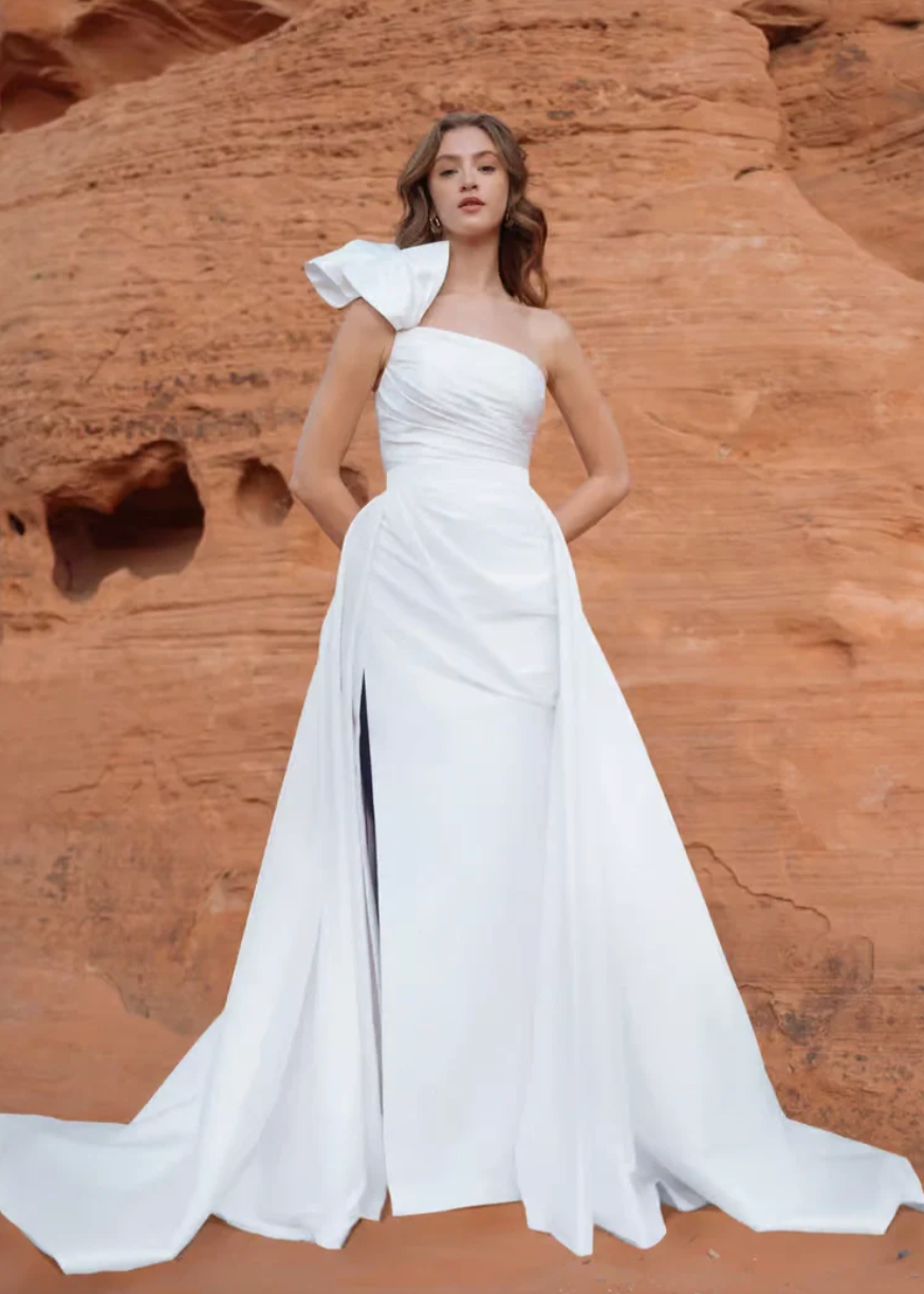 Jenny Yoo Isla is a luxurious taffeta fit and flare wedding dress featuring a one-shoulder neckline + matching overskirt!&nbsp;