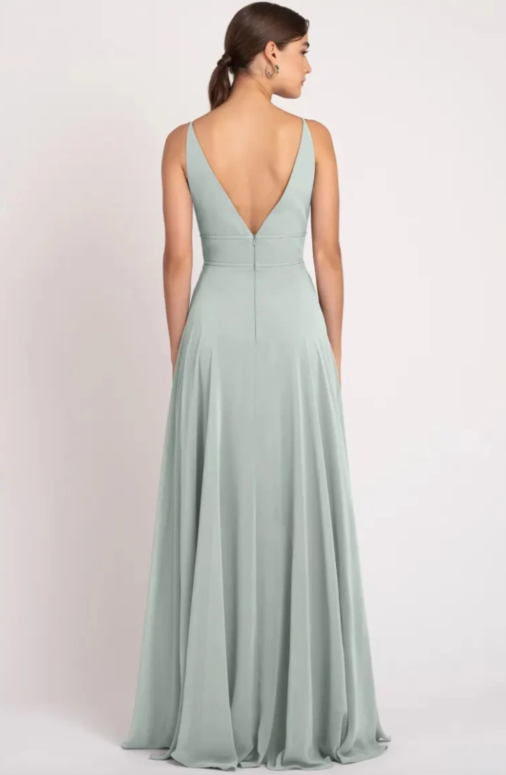 Woman wearing a light green evening gown with a plunging neckline on a white background