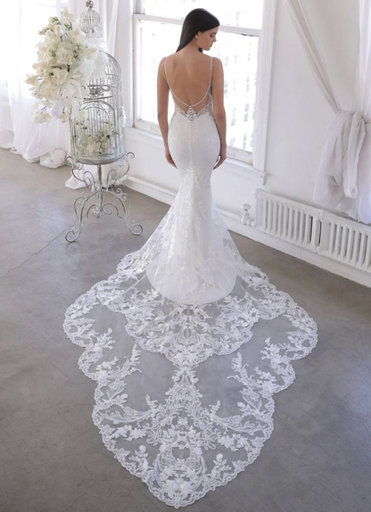 White wedding dress with a long train in a bright room