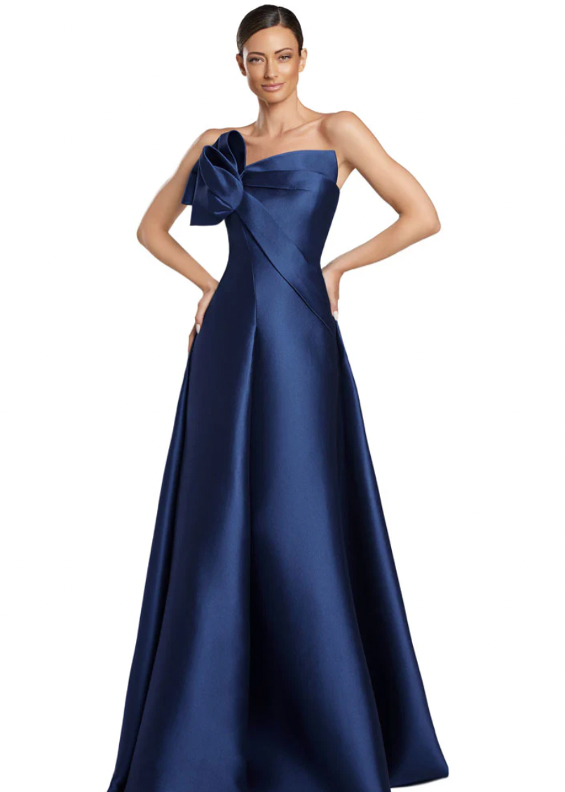 Woman wearing a blue strapless gown with a large bow on a white background