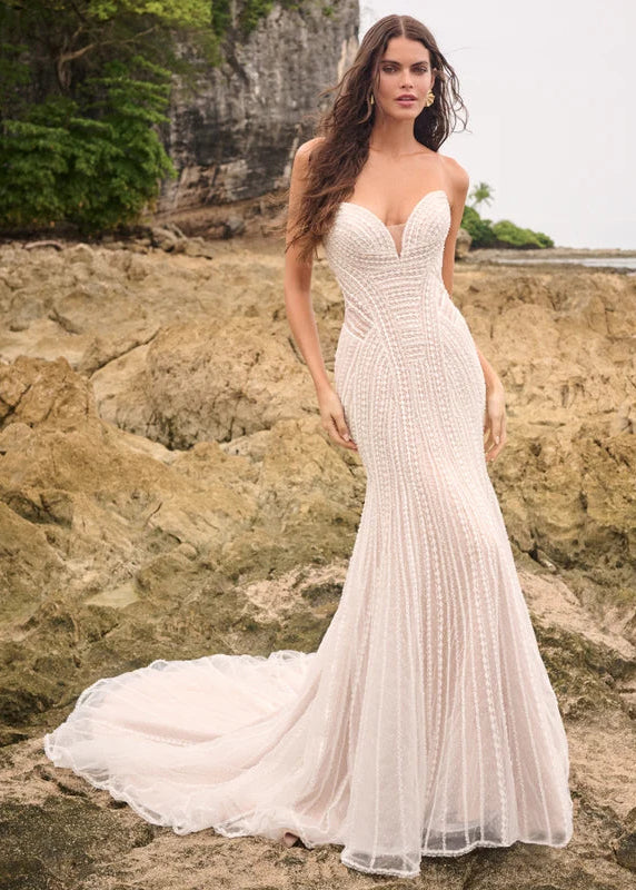 Introducing Iravanti by Sottero & Midgley, a fit-and-flare wedding gown with allover beading and a V-neckline for elegant sophistication. Featuring beaded lace trims over sparkle tulle, a deep illusion sweetheart neckline, and a Trujillo stretch jersey for comfort, this beautiful dress is perfect for special occasions. Covered buttons and a zipper closure add to the allure, while side illusion details add a delightful sparkle. Get ready to dazzle in Iravanti.

