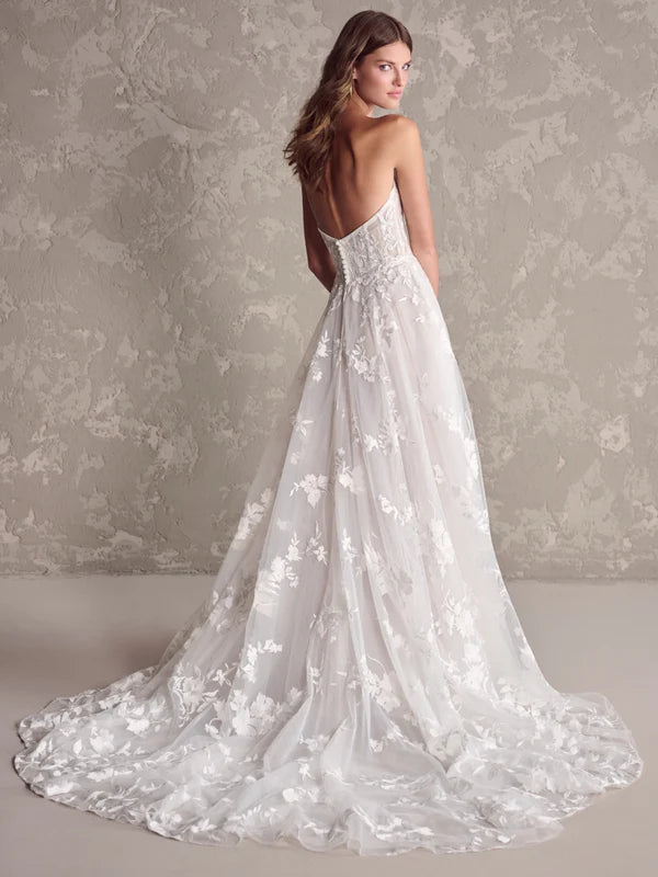 White floral wedding dress on a model against a neutral background